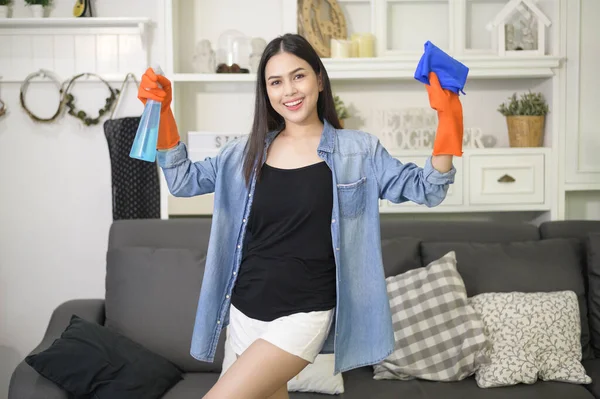 A woman with cleaning gloves using alcohol spray sanitiser to cleaning house, healthy and medical, covid-19 protection at home concept .