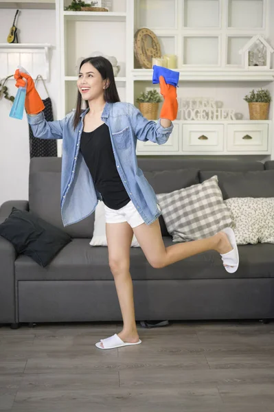 A woman with cleaning gloves using alcohol spray sanitiser to cleaning house, healthy and medical, covid-19 protection at home concept .