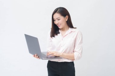 Asyalı bir kadın dizüstü bilgisayarını beyaz stüdyo arka planında tutuyor. . 