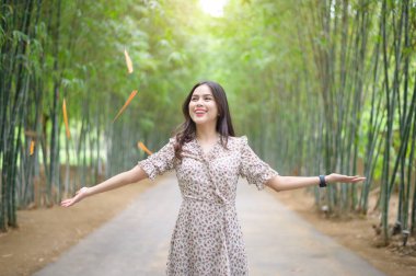 Genç bir kadın yeşil doğada kollarını açar.. 