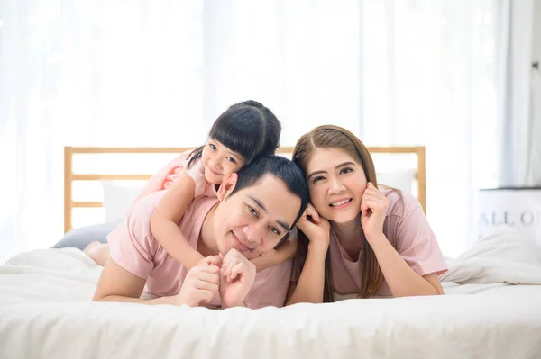 portrait of happy Asian family in white bedroom