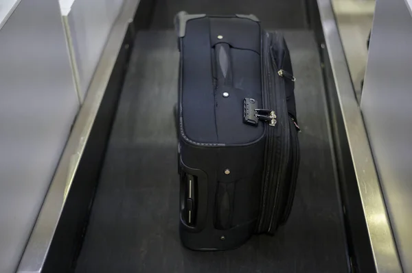 Luggage on weight on the conveyor belt at check-in counter at airport