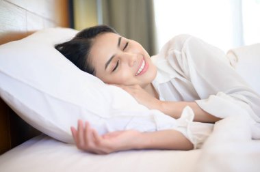 Evdeki yatağında uyuyan genç ve güzel bir kadın.