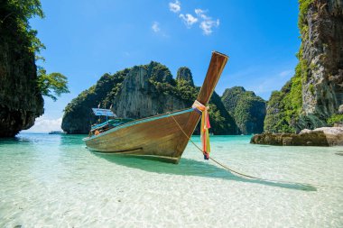 Tayland 'ın Phi phi Adaları' nda güneşli bir günde açık deniz ve gökyüzü üzerinde geleneksel uzun kuyruklu Tayland teknesi manzarası