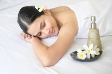 Güzel bir kadın dinleniyor ve masaj merkezinde masaj yaptırıyor. Masaj ve güzellik tedavi konsepti..