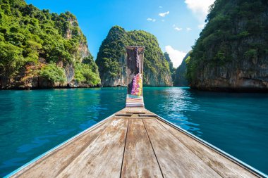 Tayland 'ın Phi phi Adaları' nda güneşli bir günde açık deniz ve gökyüzü üzerinde geleneksel uzun kuyruklu Tayland teknesi manzarası
