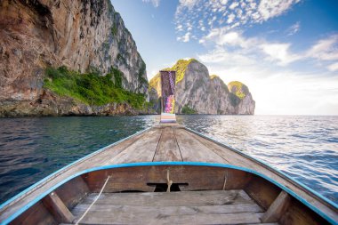 Tayland 'ın Phi phi Adaları' nda güneşli bir günde açık deniz ve gökyüzü üzerinde geleneksel uzun kuyruklu Tayland teknesi manzarası