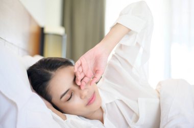 Evdeki yatağında uyuyan genç ve güzel bir kadın.