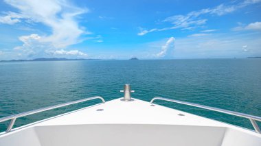 Arka planda güzel bir okyanus ve dağ olan lüks bir sürat teknesi manzarası.