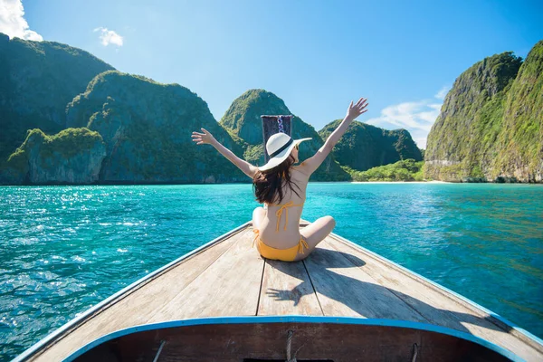 Tayland 'daki Phi phi Adaları' nda geleneksel uzun kuyruklu teknenin keyfini çıkaran mayo giymiş bir kadın görüntüsü.