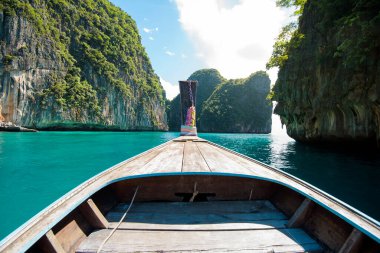Tayland 'ın Phi phi Adaları' nda güneşli bir günde açık deniz ve gökyüzü üzerinde geleneksel uzun kuyruklu Tayland teknesi manzarası