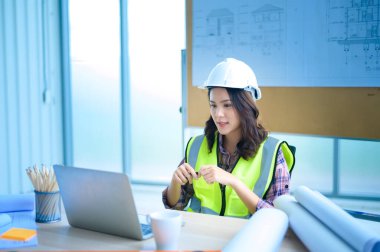 Dizüstü bilgisayar kullanan bir kadın mühendis, müşteri ya da iş ortağına görüntülü arama yapıyor