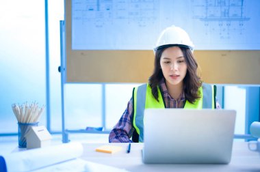 Dizüstü bilgisayar kullanan bir kadın mühendis, müşteri ya da iş ortağına görüntülü arama yapıyor