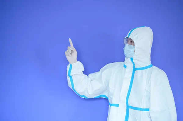 An Asian man is wearing ppe suit on purple background .