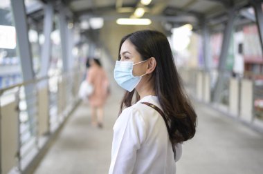 Sokak şehrinde yüz maskesi takan genç bir kadın, Coronavirus koruması, salgın altında yaşam tarzı, sağlık konsepti.