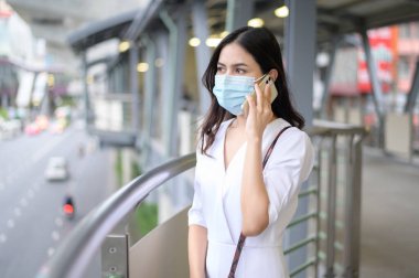 Sokak şehrinde yüz maskesi takan genç bir kadın, Coronavirus koruması, salgın altında yaşam tarzı, sağlık konsepti.