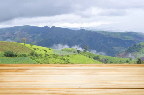 緑の山の景色に茶色の木製のテーブル — ストック写真