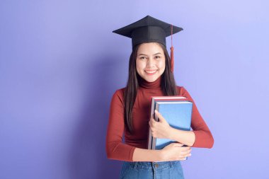 Mezuniyet şapkası menekşe arka planda genç bir üniversite öğrencisi kadının portresi. 