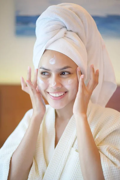 Happy Beautiful Woman White Bathrobe Applying Moisturizing Cream Face Bedroom — Stock Photo, Image