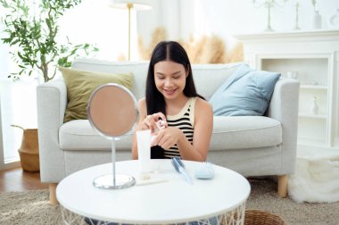 Genç Asyalı kadın evde makyaj yapıyor.