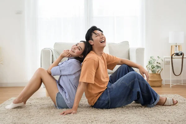 Parlak, havadar bir oturma odasında, yumuşak bir halının üzerinde sırt sırta verip rahatlayan bir çift..