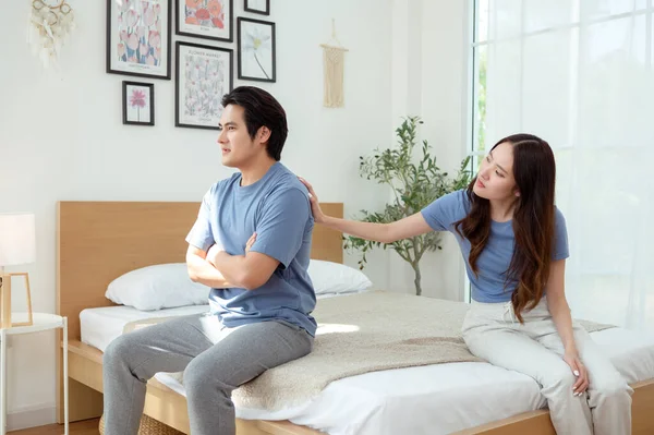 Bir çift, modern odalarında bir yatakta oturup, gerginlik ve üzüntü ifade ederler..