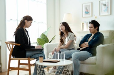 Bir çift, rahat, aydınlık bir ofis ortamında terapistle sohbet ediyor..