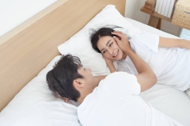 İki insan birlikte neşeli bir anı paylaşıyor, gülümsüyor ve kapalı bir ortamda kucaklaşıyorlar..