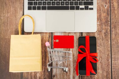  İnternetten konsept alışverişi ve teknoloji işi için el arabasında bilgisayar laptopunda alışveriş torbaları. Yüksek kalite fotoğraf