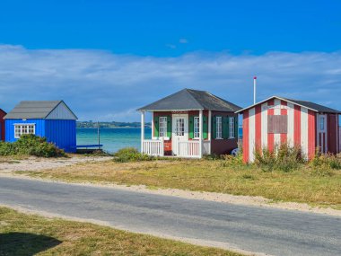 Huzurlu sahil kenarındaki renkli yazlıklar, mükemmel bir tatil ve rahatlama kaçamağı için ideal bir yer.