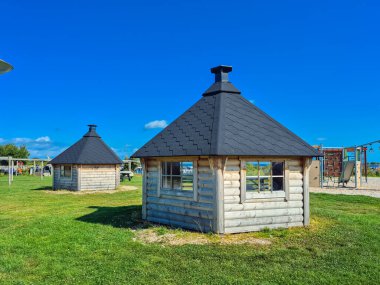 İki büyüleyici kırsal ahşap çardak hareketli, güneşli gökyüzünün altında dingin ve davetkar bir açık alan yaratıyor.
