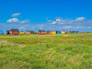 Canlı ve canlı bir sahne. Renkli kamaralar sergileniyor. Açık mavi gökyüzüne ve yemyeşil manzaraya karşı güzelce dizilmiş.