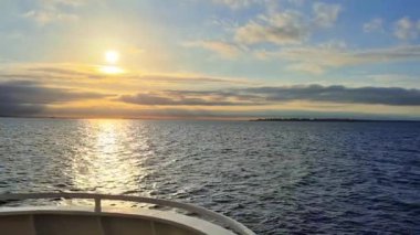 Gün batımının dingin güzelliğini deneyimlemek sakin sulara yansıyor, rahatlama ve farkındalık için ideal.