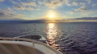 Güzel bir günbatımı sakin suları yansıtıyor, sakin manzaralar ve deniz temaları için mükemmel bir sahne yaratıyor.