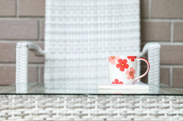 Nahaufnahme Niedliche Tasse Auf Weißem Buch Auf Verschwommenem Holz Weben — Stockfoto