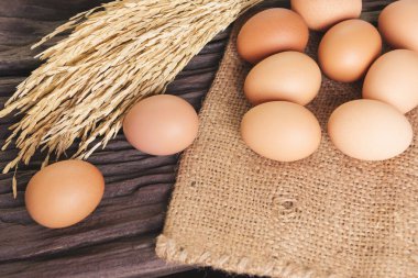 Çiğ tavuk yumurta yumurta kutusundaki yakın çekim görünümünü eski kahverengi ahşap zemin üzerinde