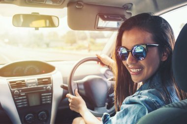 Mutlu güzellik Asyalı kadın siyah saç gülümse sunglass ve gün batımında araba mavi jean ceket. Etkileri filtreleri ve instagram ile resim