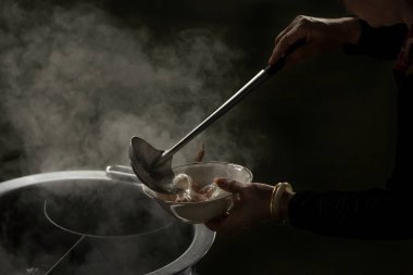 Şef şehriye yerel restoran, Tayland sokak karides ve balık eti top ile yemek yemek. siyah duman ile sıcak haşlanmış çorbası geleneksel Asya gıda şehriye yapma