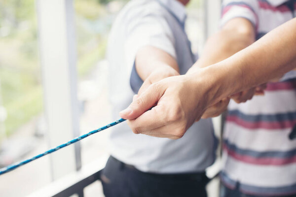 Hands of people pulling the rope cooperation concept