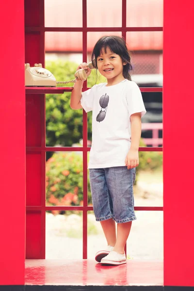 Dětský úsměv v telefonní budce — Stock fotografie