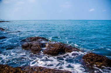 Kıyıdaki kayalarda okyanus dalgaları kırılıyor..