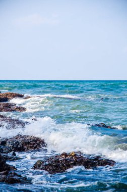 Kıyıdaki kayalarda okyanus dalgaları kırılıyor..