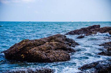 Kıyıdaki kayalarda okyanus dalgaları kırılıyor..