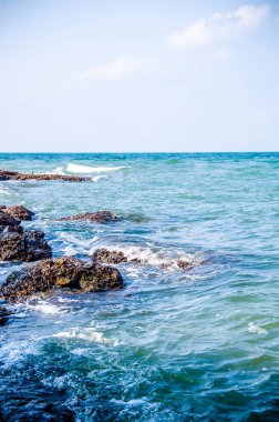 Kıyıdaki kayalarda okyanus dalgaları kırılıyor..