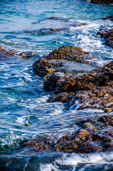 Les vagues se brisent sur les rochers du rivage. — Photo