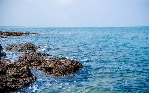 Kıyıdaki kayalarda okyanus dalgaları kırılıyor..