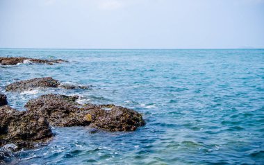 Kıyıdaki kayalarda okyanus dalgaları kırılıyor..
