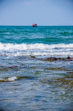 Kıyıdaki kayalarda okyanus dalgaları kırılıyor..