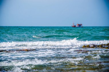 Kıyıdaki kayalarda okyanus dalgaları kırılıyor..