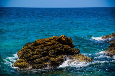 Kıyıdaki kayalarda okyanus dalgaları kırılıyor..